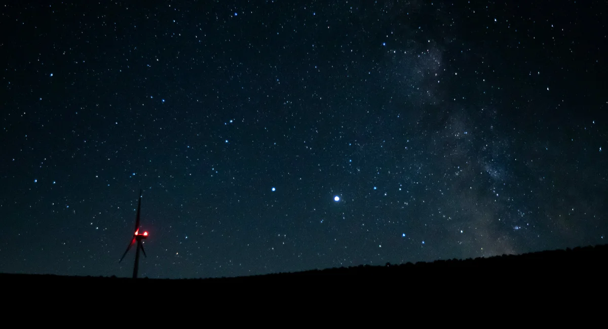 saturn and jupiter visible above Prague skyline at night
