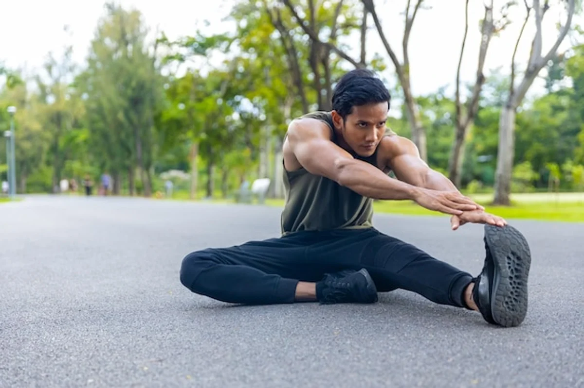 man warming up before running in urban park