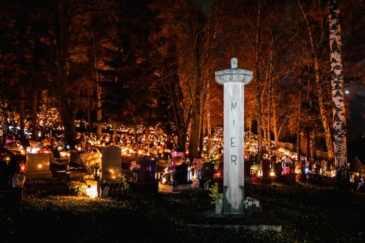 czech cemetery with candles glowing at dusk during all souls day