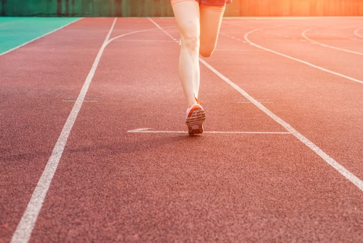 female track runner celebrating victory old stadium
