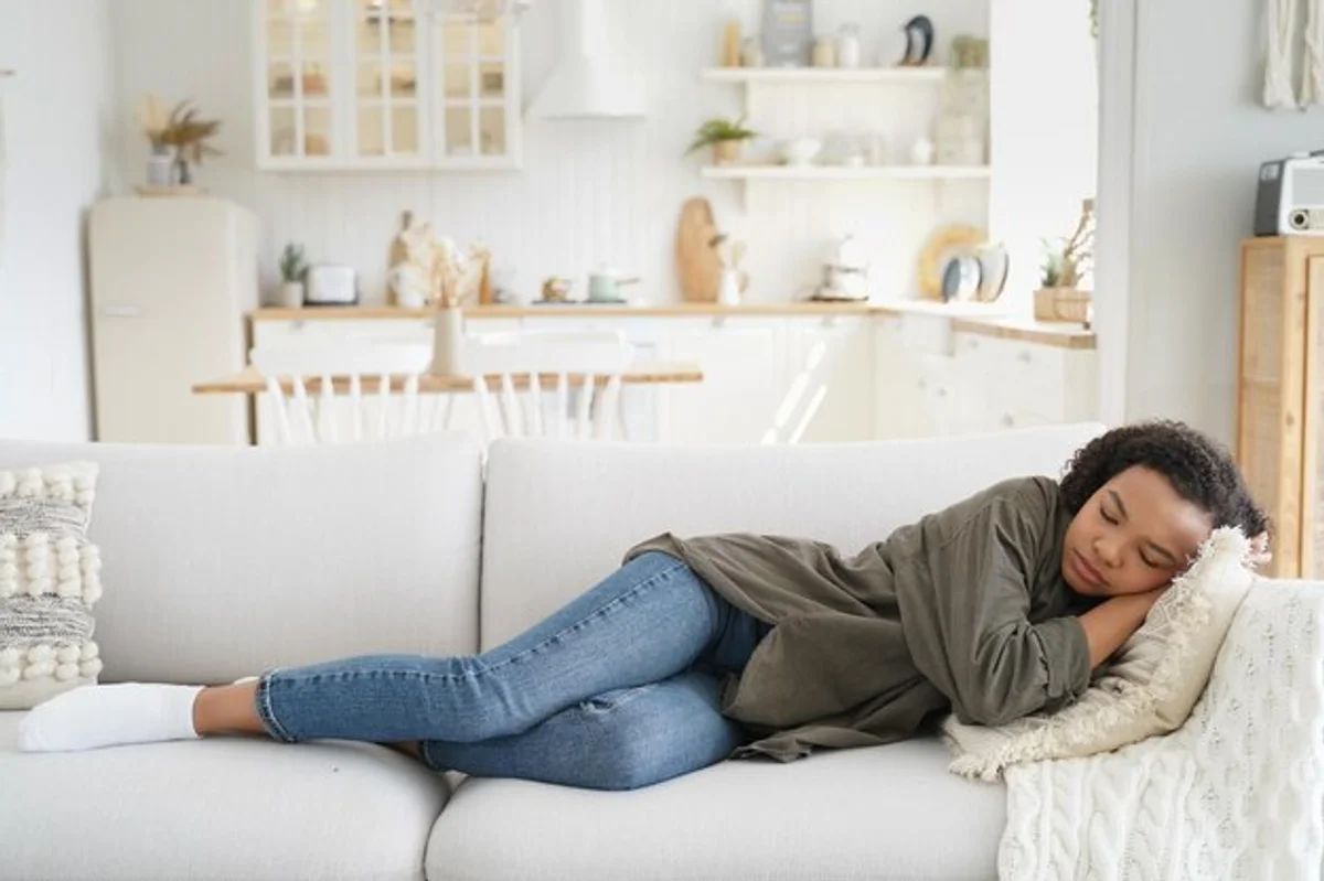 tired woman at home sofa daylight