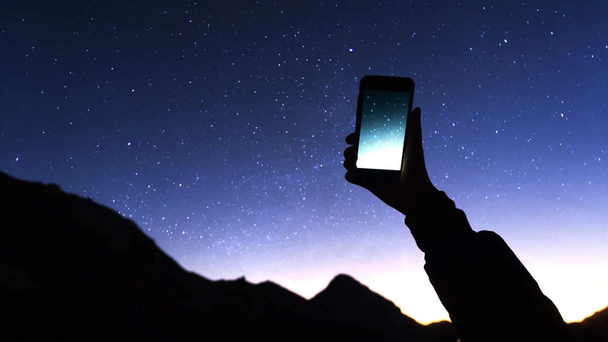 woman holding smartphone night sky planet identification app outdoors europe