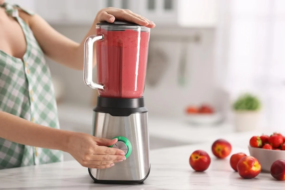 close up of hands using portable blender in modern kitchen