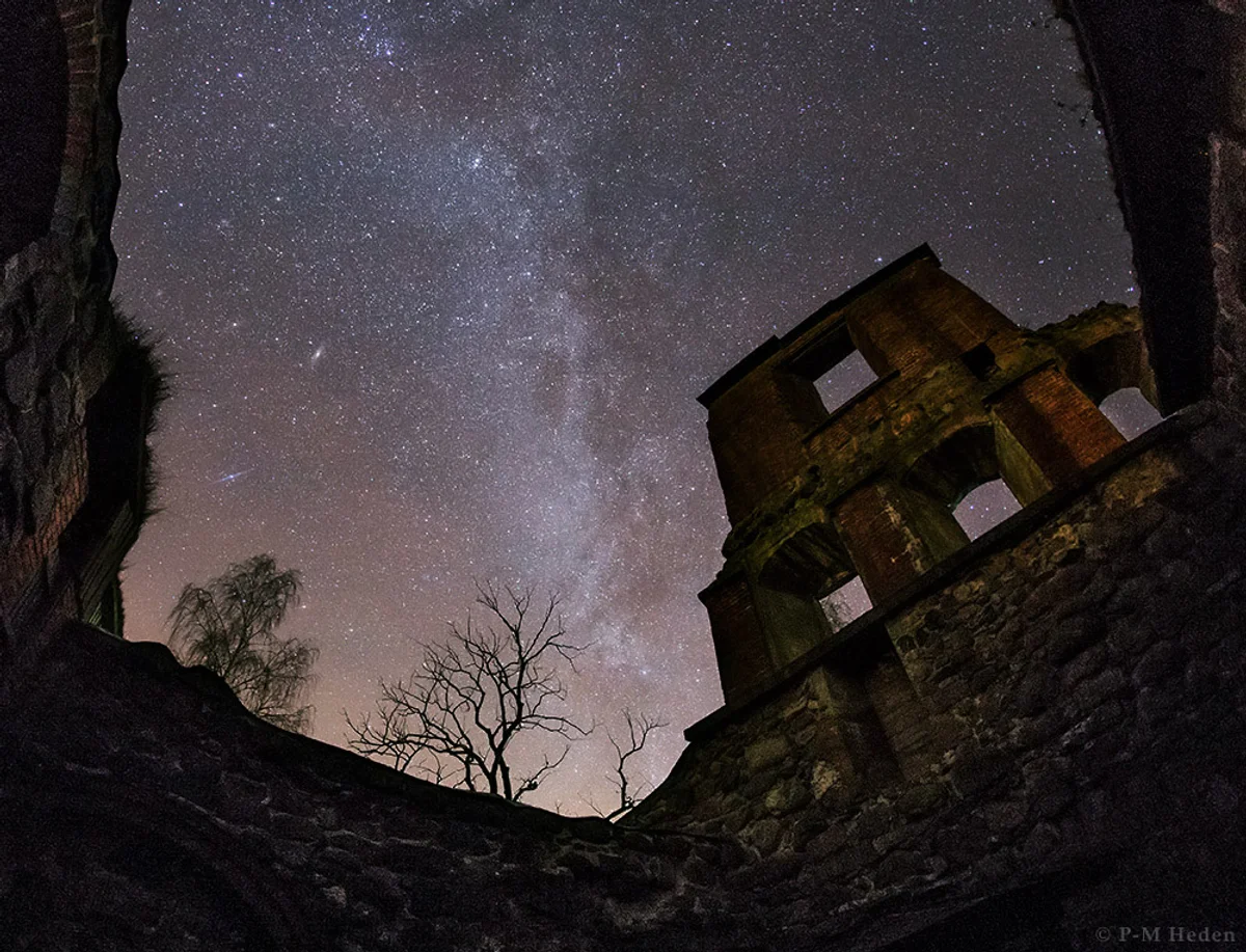 night sky and andromeda galaxy over european countryside autumn